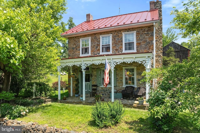 2355 Little Rd, Perkiomenville, PA 18074 - rear view of house with a chimney, a standing seam roof, stone siding, and covered porch