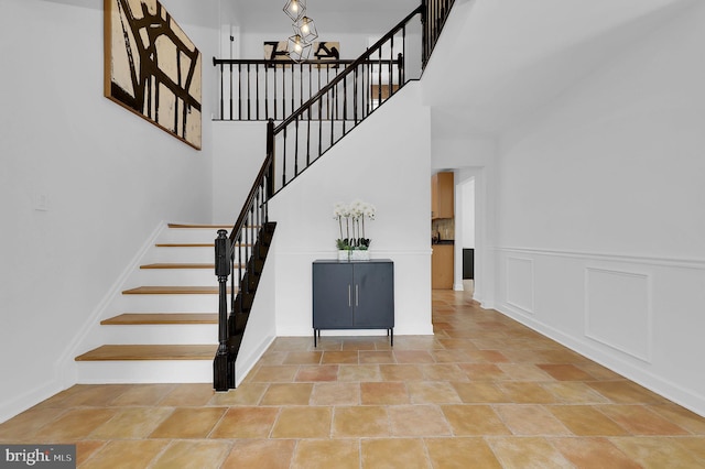 2725 Woodridge Ct, West Friendship, MD 21794 - staircase with a high ceiling, a chandelier, and stone finish floors