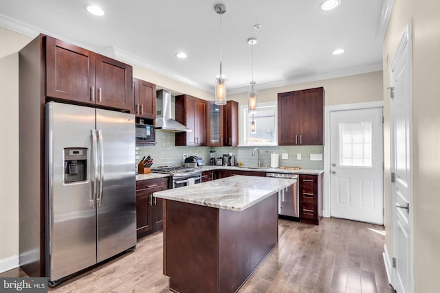 1128 S 24th St S, Philadelphia, PA 19146 - kitchen with appliances with stainless steel finishes, wall chimney exhaust hood, decorative light fixtures, tasteful backsplash, and light wood finished floors