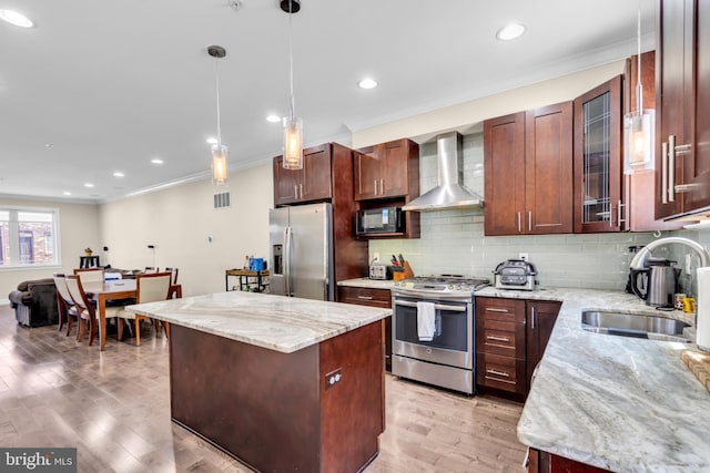 1128 S 24th St S, Philadelphia, PA 19146 - kitchen with stainless steel appliances, wall chimney exhaust hood, ornamental molding, a center island, and light wood-style floors