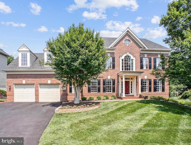 18510 Barton Creek Pl, Leesburg, VA 20176 - georgian-style home with brick siding, driveway, a garage, a front lawn, and roof with shingles