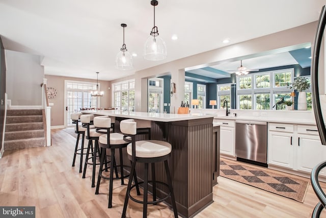 18510 Barton Creek Pl, Leesburg, VA 20176 - kitchen with dishwasher, light wood finished floors, white cabinets, a kitchen bar, and recessed lighting