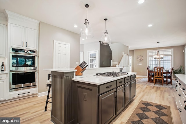 18510 Barton Creek Pl, Leesburg, VA 20176 - kitchen with appliances with stainless steel finishes, white cabinets, light wood finished floors, light countertops, and recessed lighting