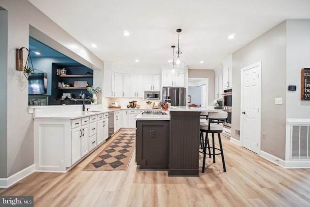 18510 Barton Creek Pl, Leesburg, VA 20176 - kitchen featuring appliances with stainless steel finishes, light wood-style floors, light countertops, white cabinets, and recessed lighting