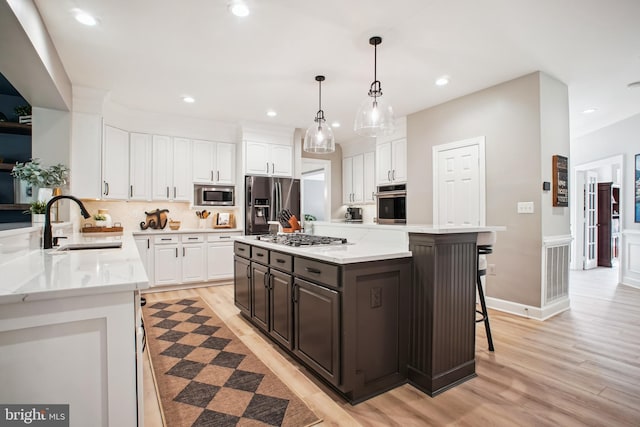 18510 Barton Creek Pl, Leesburg, VA 20176 - kitchen with stainless steel appliances, white cabinetry, a breakfast bar, light wood finished floors, and recessed lighting