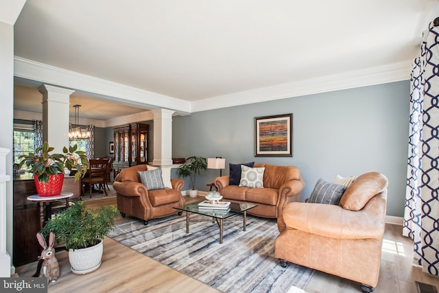 18510 Barton Creek Pl, Leesburg, VA 20176 - living room with decorative columns, wood finished floors, crown molding, and a chandelier