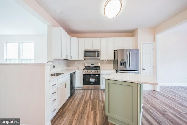 5514 Aeriel Pl, Frederick, MD 21703 - kitchen with appliances with stainless steel finishes, backsplash, light stone counters, light wood-type flooring, and a kitchen island