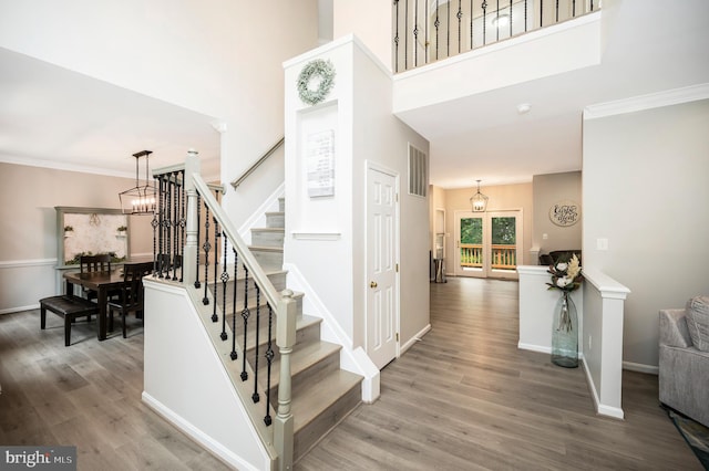 12424 Silent Wolf Dr, Manassas, VA 20112 - stairs featuring a chandelier, wood finished floors, a high ceiling, and crown molding