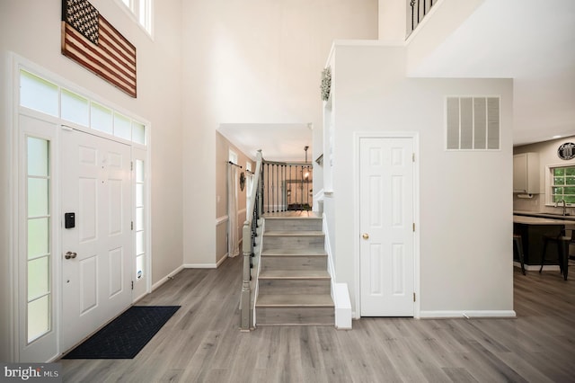 12424 Silent Wolf Dr, Manassas, VA 20112 - foyer entrance with a towering ceiling, wood finished floors, and stairway