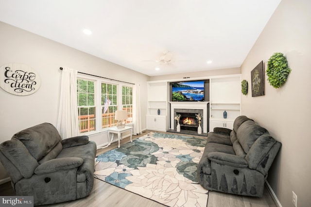 12424 Silent Wolf Dr, Manassas, VA 20112 - living room featuring light wood finished floors, a fireplace, recessed lighting, ceiling fan, and built in features