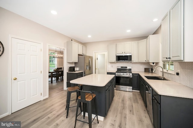 12424 Silent Wolf Dr, Manassas, VA 20112 - kitchen featuring stainless steel appliances, a kitchen breakfast bar, a center island, light wood-style flooring, and recessed lighting