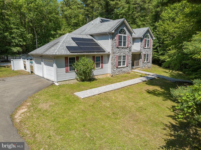 2299 Long Acre Dr, Effort, PA 18330 - traditional home with asphalt driveway, roof mounted solar panels, roof with shingles, a front lawn, and stone siding