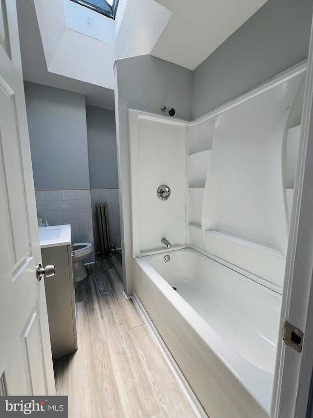1609 S 28th St, Philadelphia, PA 19145 - full bath with a skylight, tile walls, vanity, wood finished floors, and shower / tub combination