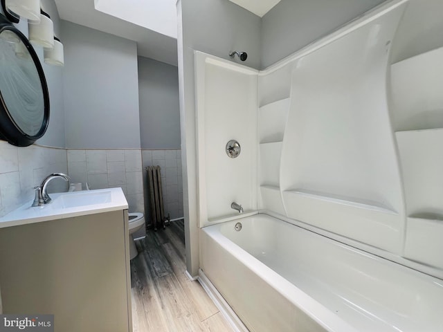 1609 S 28th St, Philadelphia, PA 19145 - full bathroom featuring wood finished floors, vanity, bathtub / shower combination, tile walls, and wainscoting