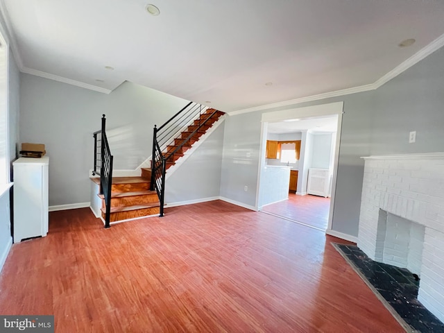 1609 S 28th St, Philadelphia, PA 19145 - unfurnished living room featuring wood finished floors, stairway, crown molding, washer / dryer, and a brick fireplace