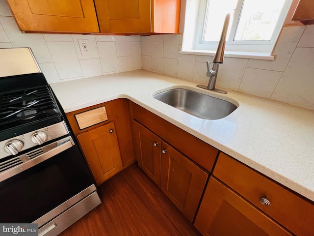 1609 S 28th St, Philadelphia, PA 19145 - kitchen with stainless steel stove, brown cabinets, backsplash, light stone countertops, and dark wood finished floors
