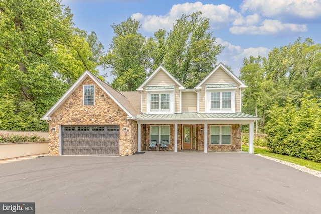 1631 E Strasburg Rd, West Chester, PA 19380 - view of front of house with a porch, a standing seam roof, driveway, stone siding, and a metal roof