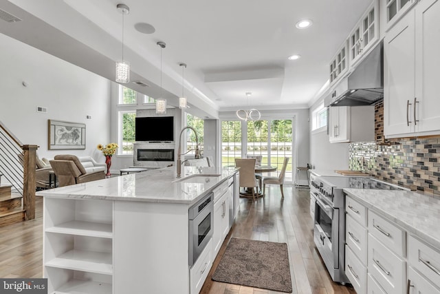 1631 E Strasburg Rd, West Chester, PA 19380 - kitchen with appliances with stainless steel finishes, under cabinet range hood, wood finished floors, open shelves, and white cabinetry