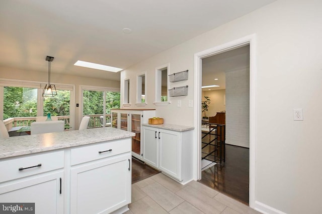 2301 N Tracy St, Alexandria, VA 22311 - kitchen with white cabinetry, plenty of natural light, pendant lighting, and light stone countertops