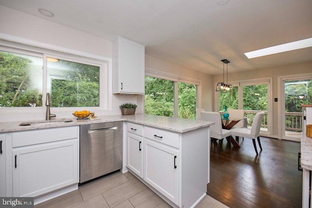 2301 N Tracy St, Alexandria, VA 22311 - kitchen featuring dishwasher, white cabinets, a skylight, and a peninsula