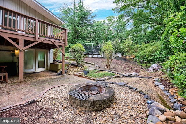 2301 N Tracy St, Alexandria, VA 22311 - view of yard with an outdoor fire pit, a trampoline, a wooden deck, and a patio area
