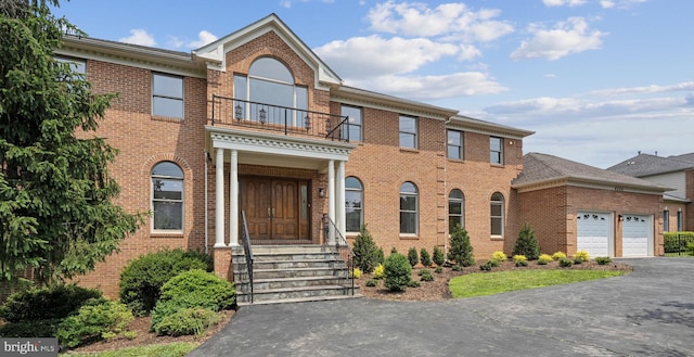 9309 Bells Mill Rd, Potomac, MD 20854 - colonial inspired home with a balcony, asphalt driveway, and brick siding