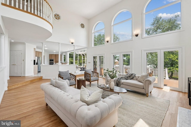 9309 Bells Mill Rd, Potomac, MD 20854 - living room featuring french doors, a high ceiling, plenty of natural light, light wood finished floors, and ornate columns