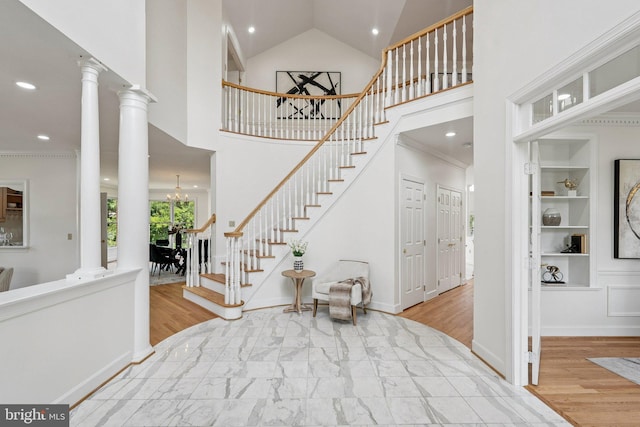 9309 Bells Mill Rd, Potomac, MD 20854 - entrance foyer featuring stairway, high vaulted ceiling, wood finished floors, a chandelier, and decorative columns