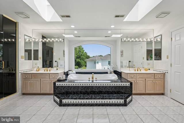 9309 Bells Mill Rd, Potomac, MD 20854 - bathroom with a skylight, two vanities, a bath, and recessed lighting