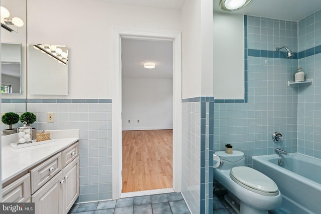 9309 Bells Mill Rd, Potomac, MD 20854 - full bath featuring tile walls, vanity, tub / shower combination, wainscoting, and tile patterned flooring