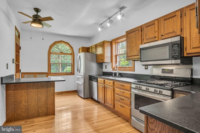 302 Bailey St, New Cumberland, PA 17070 - kitchen featuring stainless steel appliances, a ceiling fan, dark countertops, brown cabinetry, and light wood finished floors