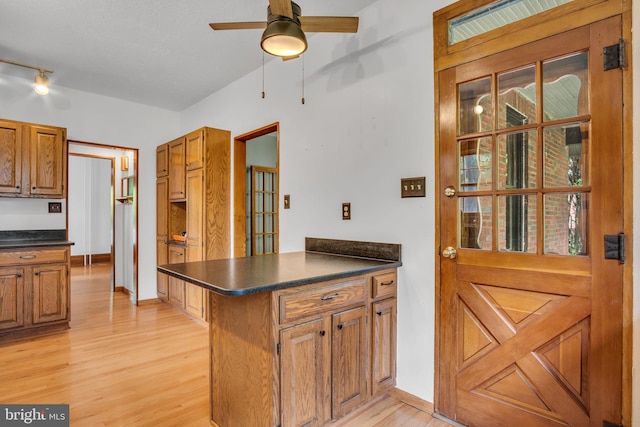 302 Bailey St, New Cumberland, PA 17070 - kitchen featuring dark countertops, light wood-style floors, a peninsula, ceiling fan, and brown cabinetry