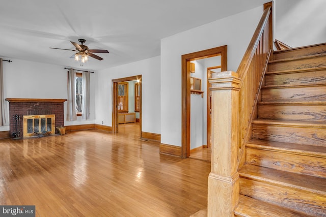 302 Bailey St, New Cumberland, PA 17070 - unfurnished living room with a ceiling fan, stairway, wood finished floors, and a brick fireplace