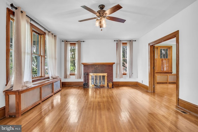 302 Bailey St, New Cumberland, PA 17070 - unfurnished living room with radiator, wood-type flooring, healthy amount of natural light, and a fireplace