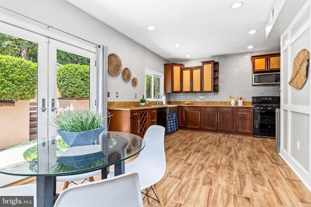 3010 26th St NE, Washington, DC 20018 - kitchen featuring black appliances, recessed lighting, backsplash, light wood finished floors, and brown cabinets