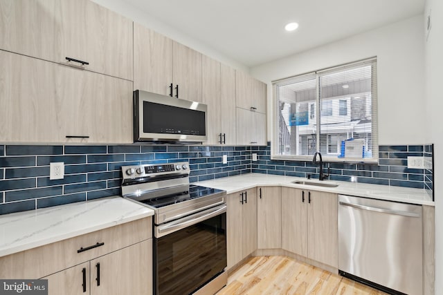 5937 Osage Ave Unit B, Philadelphia, PA 19143 - kitchen with appliances with stainless steel finishes, light brown cabinetry, a sink, light stone countertops, and modern cabinets