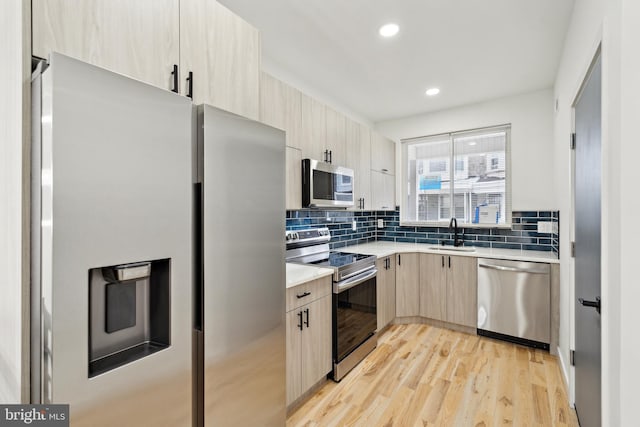 5937 Osage Ave Unit B, Philadelphia, PA 19143 - kitchen featuring stainless steel appliances, light brown cabinets, a sink, light countertops, and backsplash
