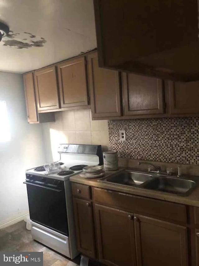 2914 Rutledge St, Philadelphia, PA 19134 - kitchen with range with electric stovetop, a sink, decorative backsplash, and baseboards