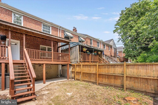 8119 Clyde Bank Rd, Towson, MD 21286 - rear view of property with stairway, brick siding, a deck, and a chimney