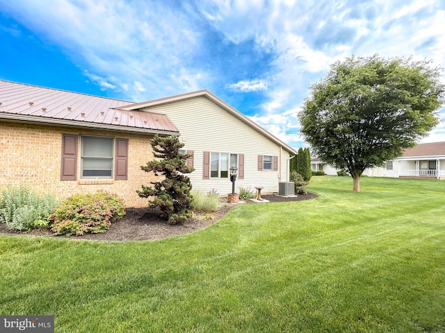 60 Parkwood Dr, Greencastle, PA 17225 - view of home's exterior with central AC unit, a lawn, metal roof, and brick siding