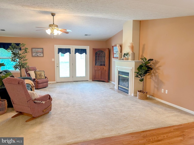 60 Parkwood Dr, Greencastle, PA 17225 - living area with baseboards, ceiling fan, a fireplace with flush hearth, a textured ceiling, and carpet flooring