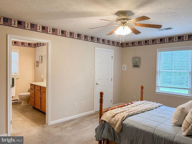60 Parkwood Dr, Greencastle, PA 17225 - bedroom featuring multiple windows, a baseboard heating unit, a textured ceiling, baseboards, and ensuite bathroom