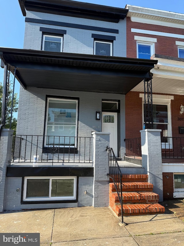 3019 Mcelderry St, Baltimore, MD 21205 - view of property featuring brick siding and a porch