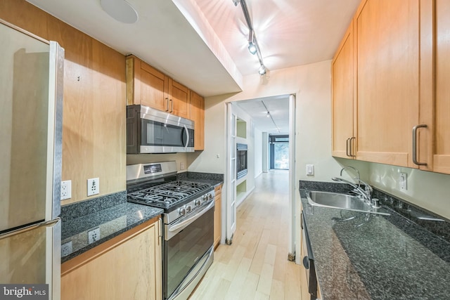 1520 16th St NW Unit 101, Washington, DC 20036 - kitchen with appliances with stainless steel finishes, track lighting, light wood finished floors, and dark stone counters