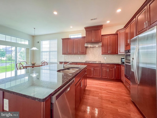 245 Carson Way, Yardley, PA 19067 - kitchen with appliances with stainless steel finishes, a sink, under cabinet range hood, light wood-type flooring, and backsplash