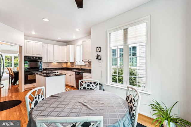13298 Fieldstone Way, Gainesville, VA 20155 - kitchen with a center island, white cabinetry, light wood-type flooring, dishwashing machine, and tasteful backsplash