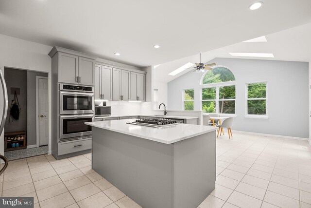 818 Northridge Way, Severna Park, MD 21146 - kitchen featuring stainless steel appliances, a skylight, gray cabinetry, light countertops, and light tile patterned flooring