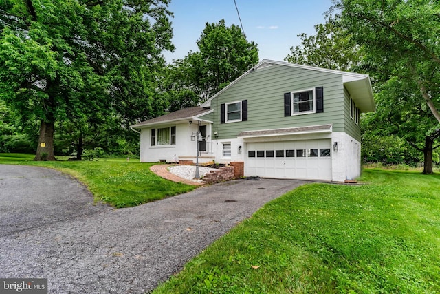 101 Horners Rd, Carlisle, PA 17015 - tri-level home with a garage, asphalt driveway, a front lawn, and brick siding