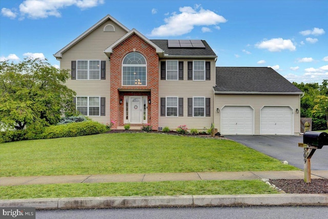 509 W Reeser St, Leesport, PA 19533 - view of front of home featuring solar panels, an attached garage, driveway, a front yard, and a shingled roof