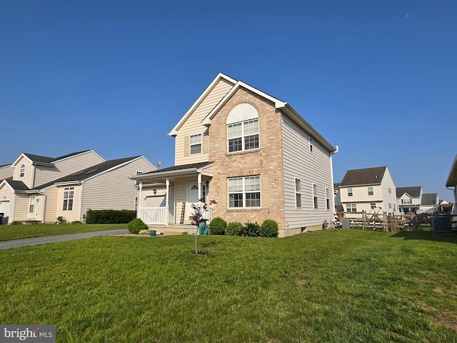 79 Liborio Ln, Smyrna, DE 19977 - traditional-style home with a porch, a front yard, and brick siding